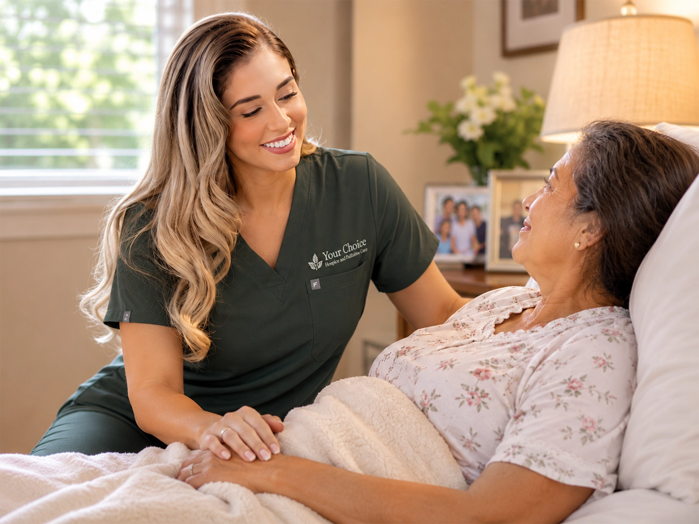 Your Choice Hospice nurse holding a smiling elderly woman's hand during in-home hospice care in Houston.